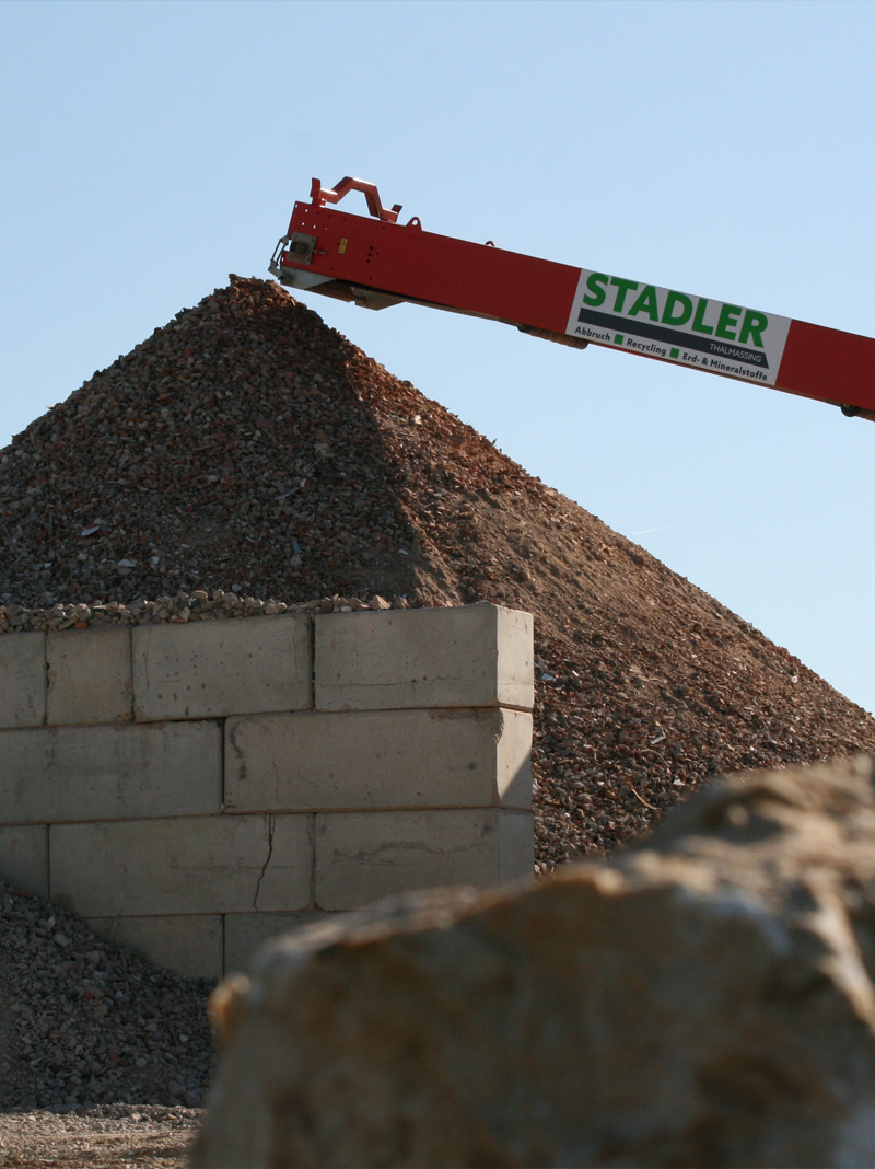 Förderband der Firma Stadler beschickt Schutthaufen auf einem Recyclingplatz